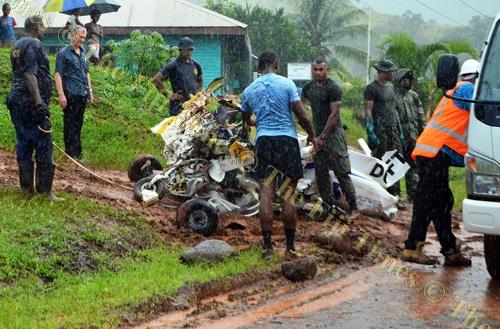 Members of the rescue teams prepare to load part of the Cessna 172 wreckage on to a truck. Picture: LUKE RAWALAI