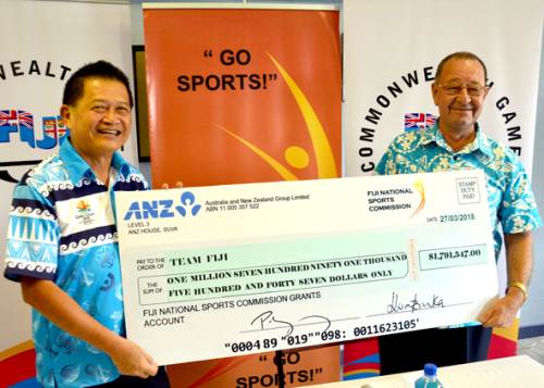 Team Fiji deputy chef de mission Christopher Yee, left, receives the cheque from Fiji National Sports Commission chairperson Peter Mazey during a press conference at the FASANOC office in Suva this morning. Picture: JONACANI LALAKOBAU