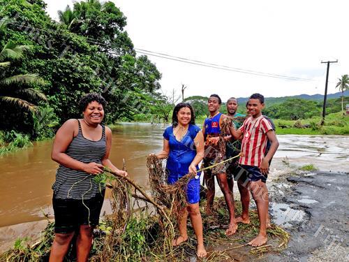 Youths of Bulileka, Labasa clear debris piled on a bridge brought by the flood. Picture: LUISA QIOLEVU