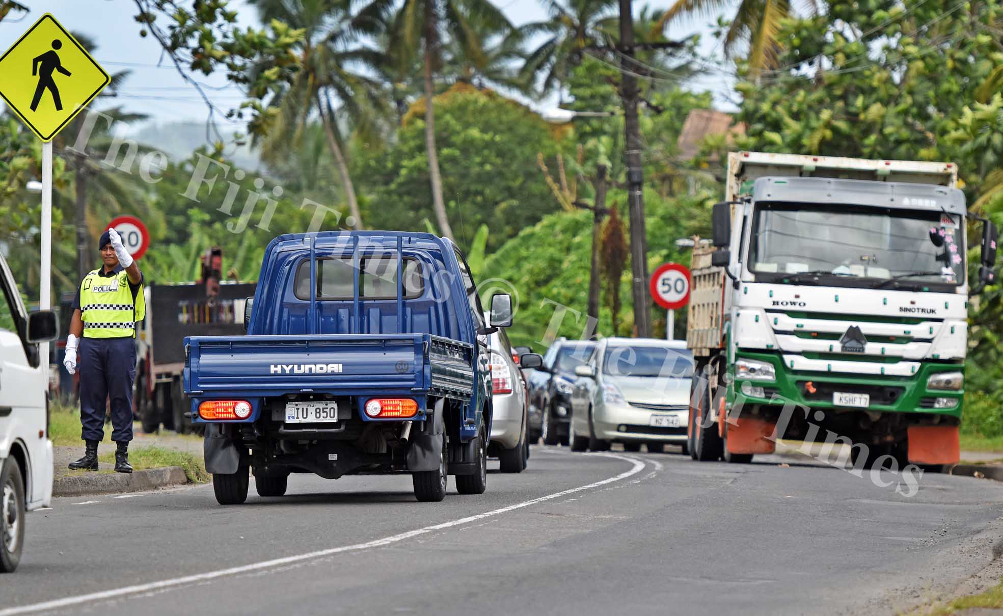 A police officer directs the traffic jam along Queens road near Lami town during a truck (on right) broke down near Lami Village in Lami yesterday. Picture: RAMA