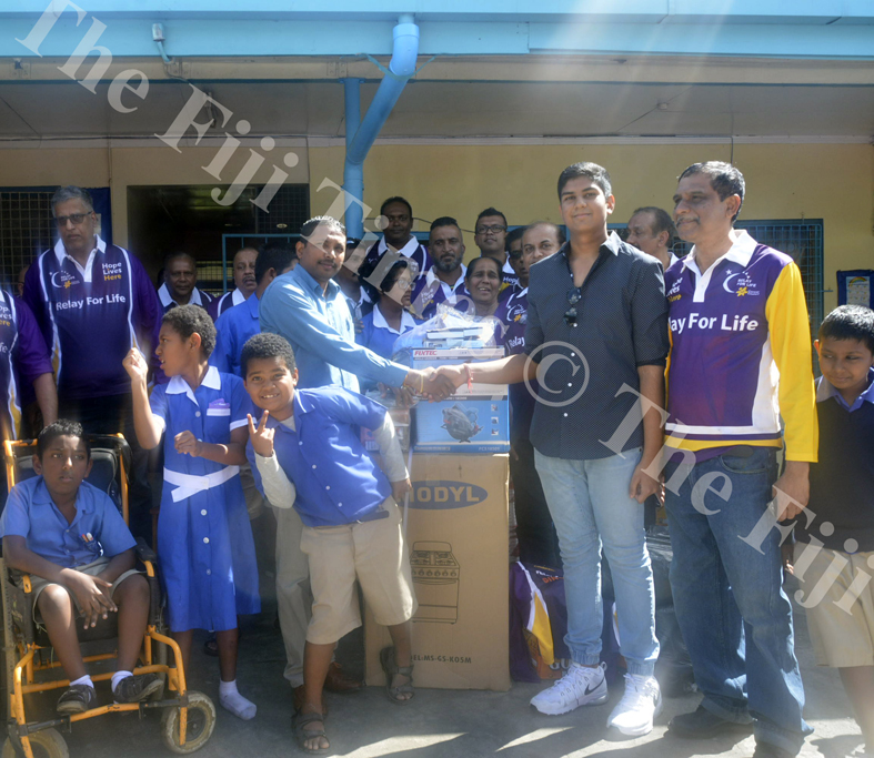 (R-L) Raben Singh and son Shiv Bhan Sngh, 15, hand over the donated items to Lautoka School for Special Education assistant head teacher Kailash Pillay in Lautoka yesterday. Picture: REPEKA NASIKO