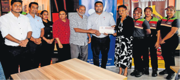 FENC Fiji founder John Samy, fifth from left, and FENC national executive coordinator Nirmala Nambiar, fourth from right, flank Burger King general manager Kavinesh Reddy after the cheque presentation yesterday. Picture: JONA KONATACI