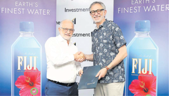 Investment Fiji deputy board chairman Mark Halabe, left, completes the sponsorship deal signing in a handshake with The Wonderful Company and FIJI Water executive vice president and general counsel Craig Cooper. Picture: INVESTMENT FIJI/ SUPPLIED